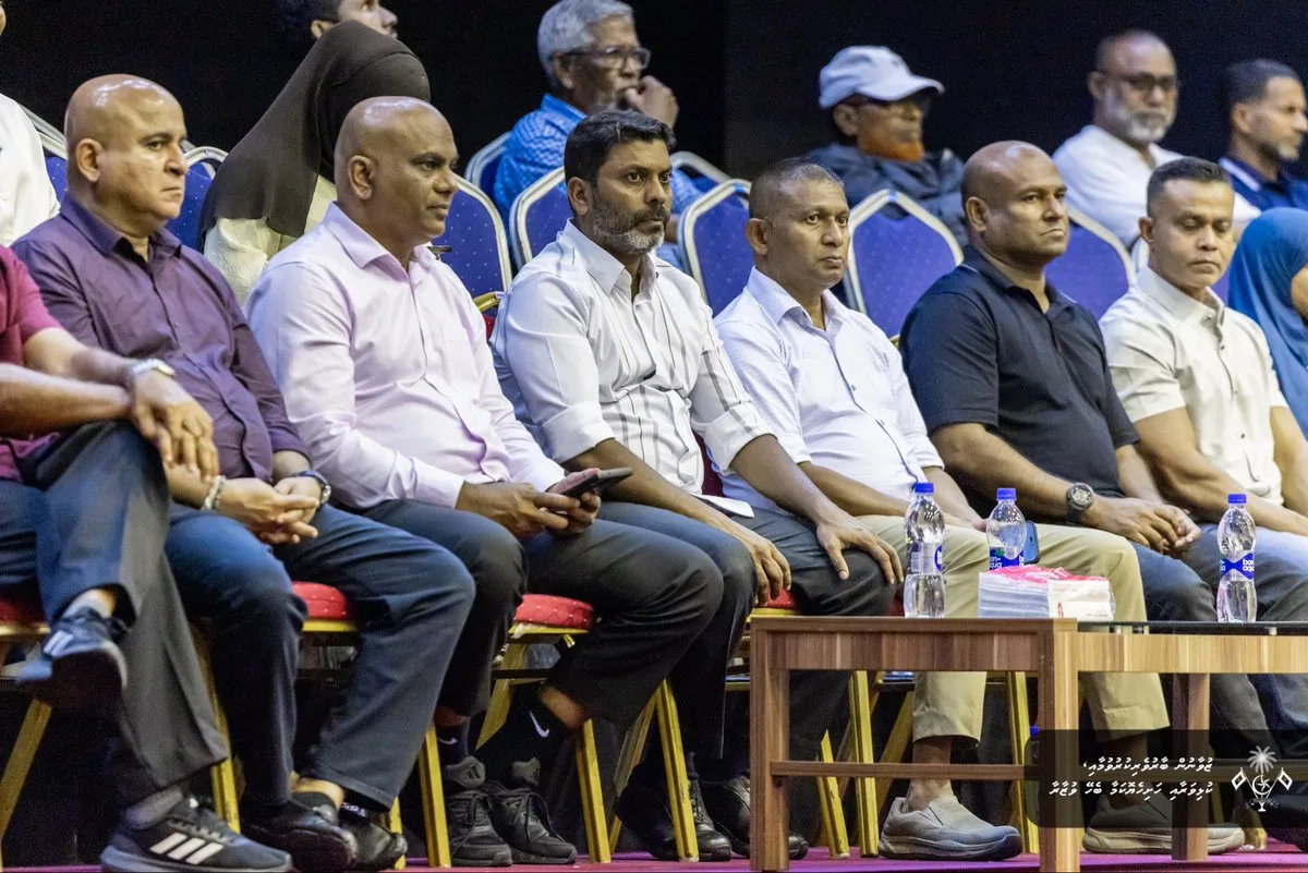 Sports minister presenting trophy to Dhivehi Sifainge Club volleyball team